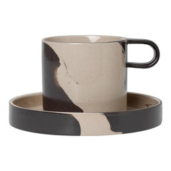 Stylish beige and black patterned cup with a matching saucer, featuring a modern, artistic design.