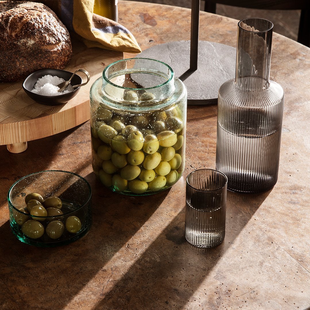 "Elegant glass containers in green and gray hues, featuring unique textures and patterns, perfect for stylish dining."