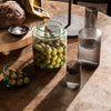 "Elegant glass containers in green and gray hues, featuring unique textures and patterns, perfect for stylish dining."