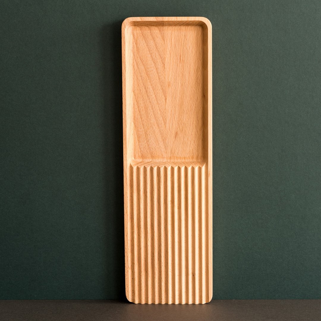 "Light wood serving tray with a smooth top and ribbed bottom, showcasing natural patterns and textures."