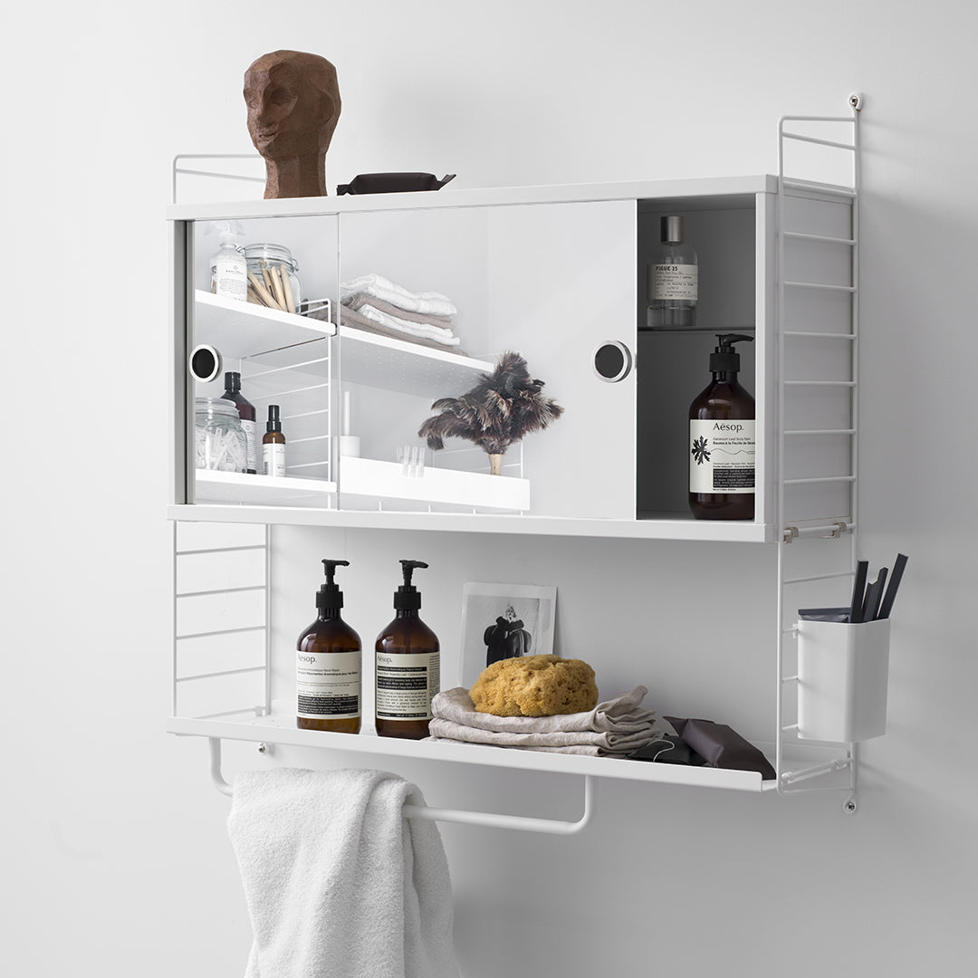 White wall-mounted shelf with glass doors, showcasing a minimalist design and sleek, modern lines.