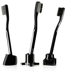 Set of three black toothbrushes with sleek designs and varying ergonomic shapes. Elegant and modern aesthetic.